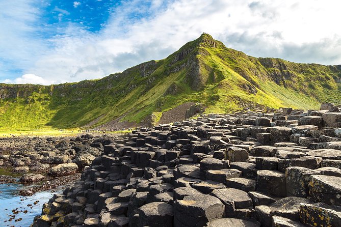 Person standing on top of Giant's Causeway basalt columns above the Atlantic Ocean